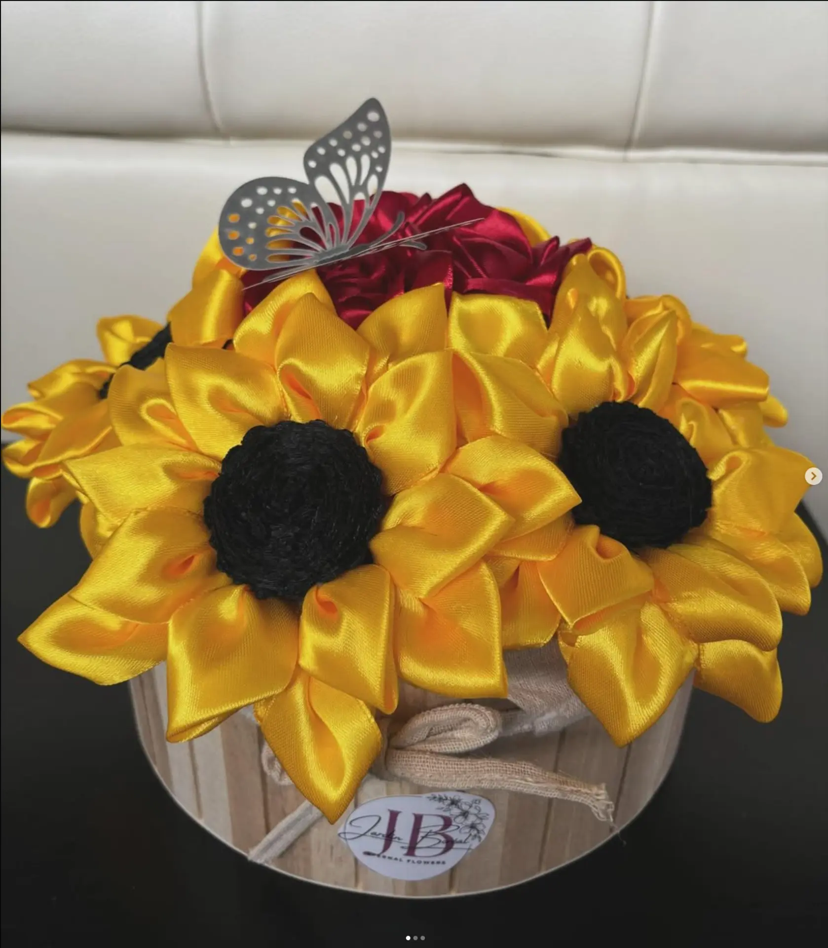 Handmade satin sunflowers with burgundy roses in a wooden container marked with the Jardin Boréal logo
